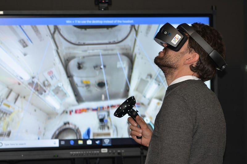 A man using a VR headset and joysticks