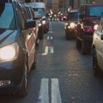 A congested city street lined with cars stuck in traffic at dusk, showcasing urban life.