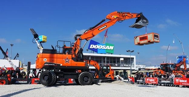 Orange Doosan excavator lifting a container